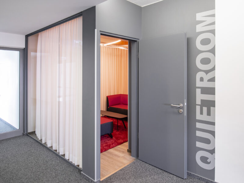 Außenansicht des Quietroom. Einsicht durch die Glaswand kann mit einem Vorhang verhindert werden. Abschließbarer Raum für Privatsphäre.